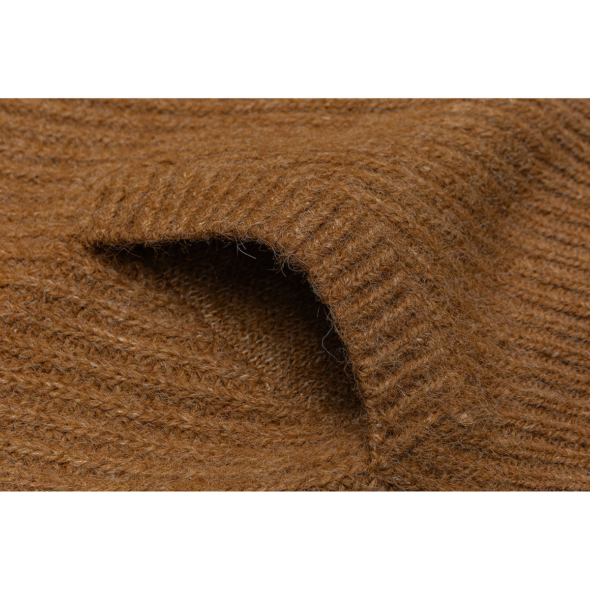 Close-up of camel-brown knit fabric folded over itself, showing the fuzzy texture and stitches.