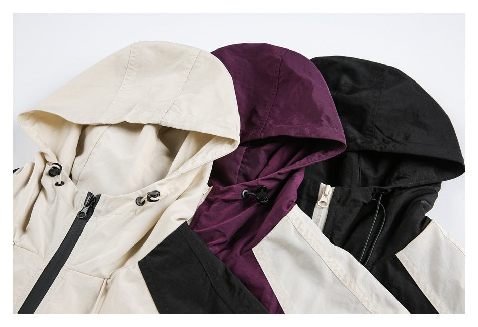 Three colorways of a hooded jacket arranged together in cream, plum, and black, showing the hoods and front details.