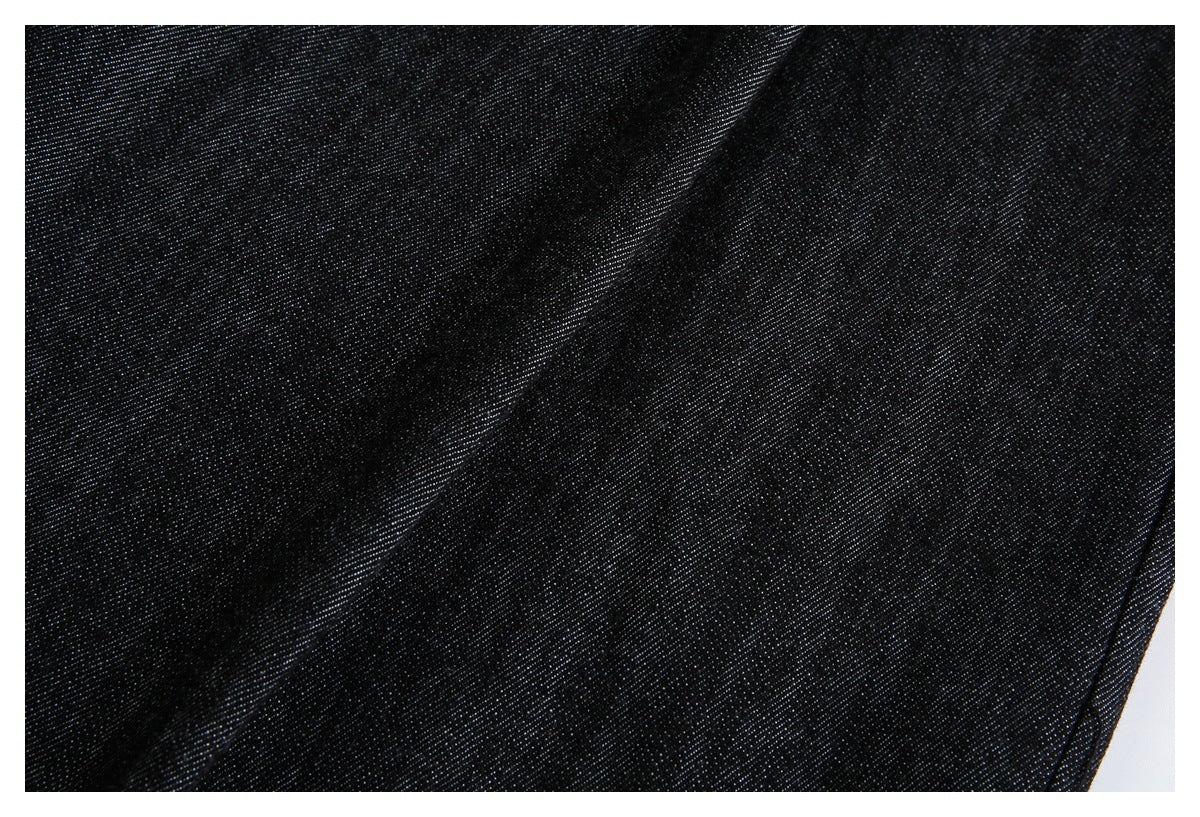 Close-up of the fine diagonal weave and dark finish of black denim.