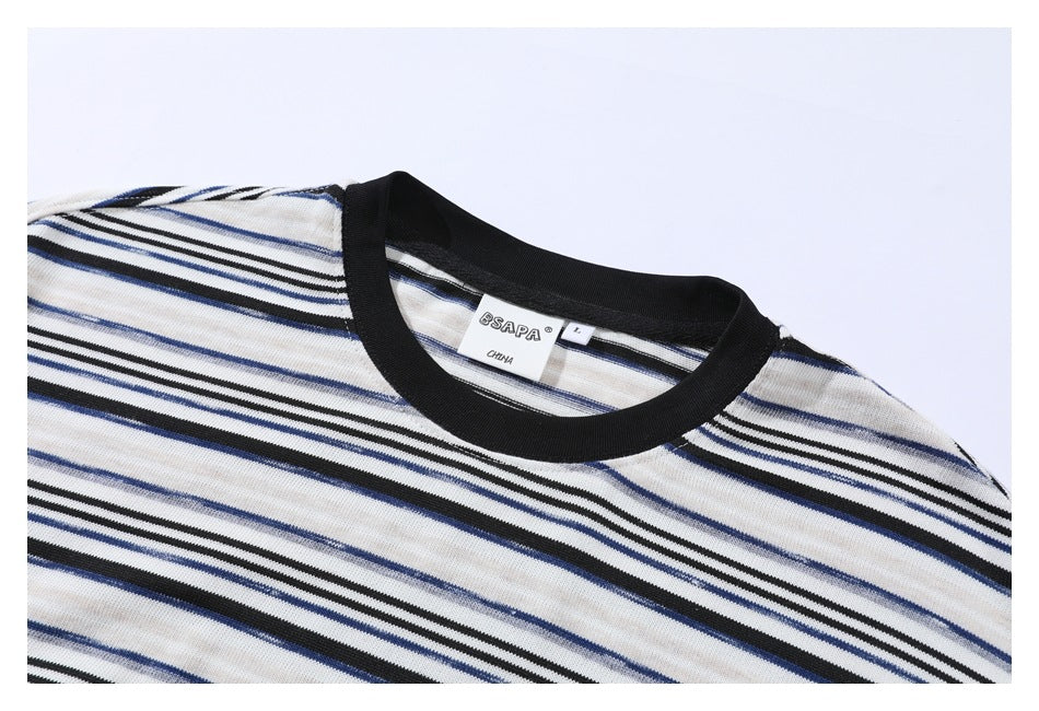 Close-up of a cream striped shirt neckline with black ribbed trim and a visible inner label.