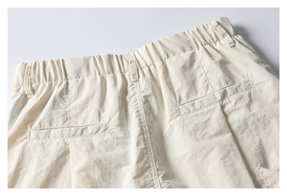 Back view of ivory shorts with an elastic waistband, belt loops, and two welt pockets.