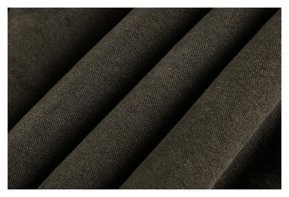 Close-up of dark olive-brown fabric arranged in folds, showing its textured surface.