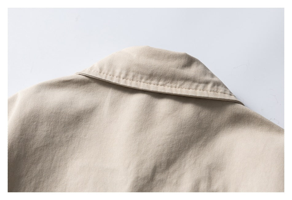 Close-up of the upper back of a beige jacket, showing its broad collar and shoulder seams.