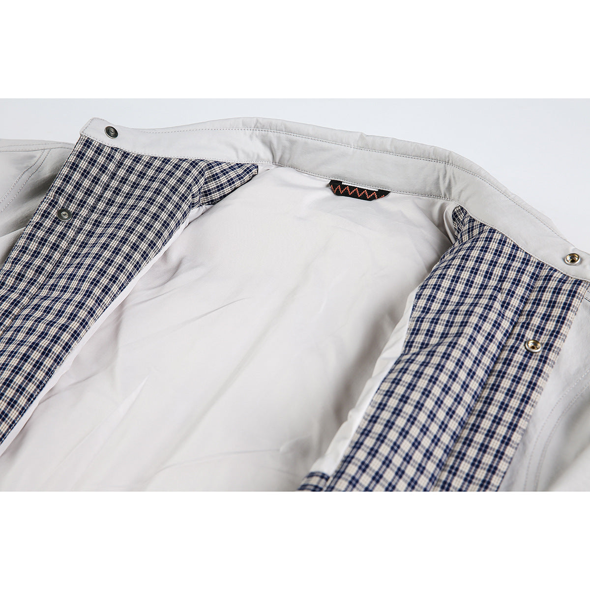 Open light gray jacket showing navy-and-white checked lining, snap fasteners and inner collar.