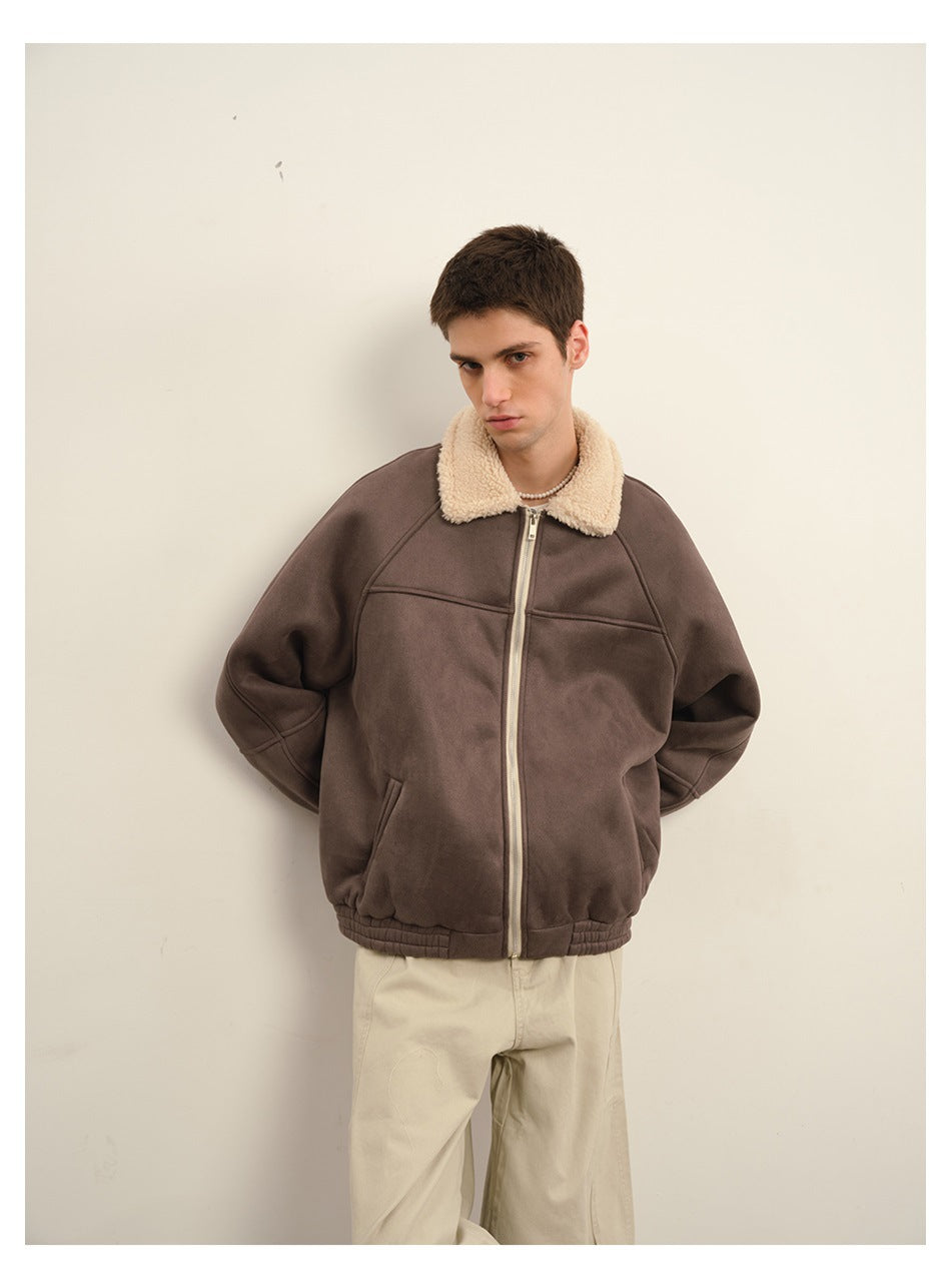 Model standing against a wall in a brown zip-front jacket with a fleece-textured collar and light khaki pants