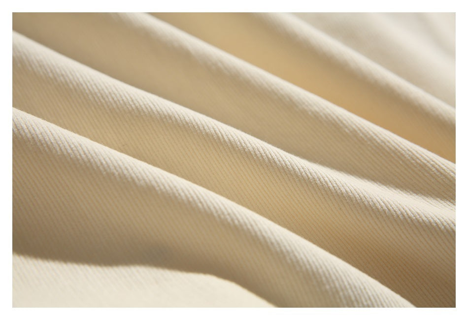 Close-up of cream-colored fabric with fine ribs and soft folds.