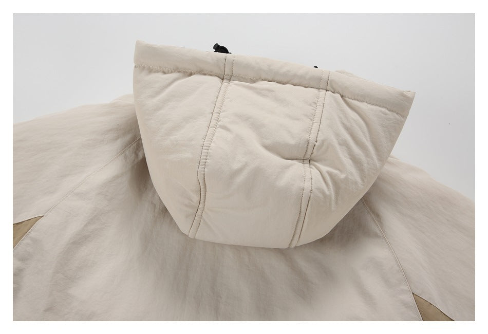 Close-up of the cream jacket's hood, showing stitched panels and a dark drawcord.