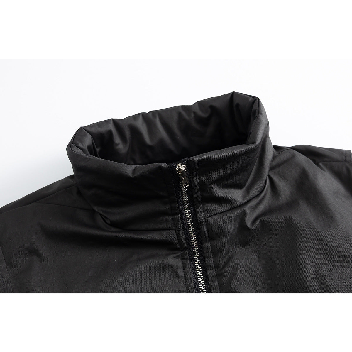 Close-up of a black jacket's tall stand collar and silver front zipper.