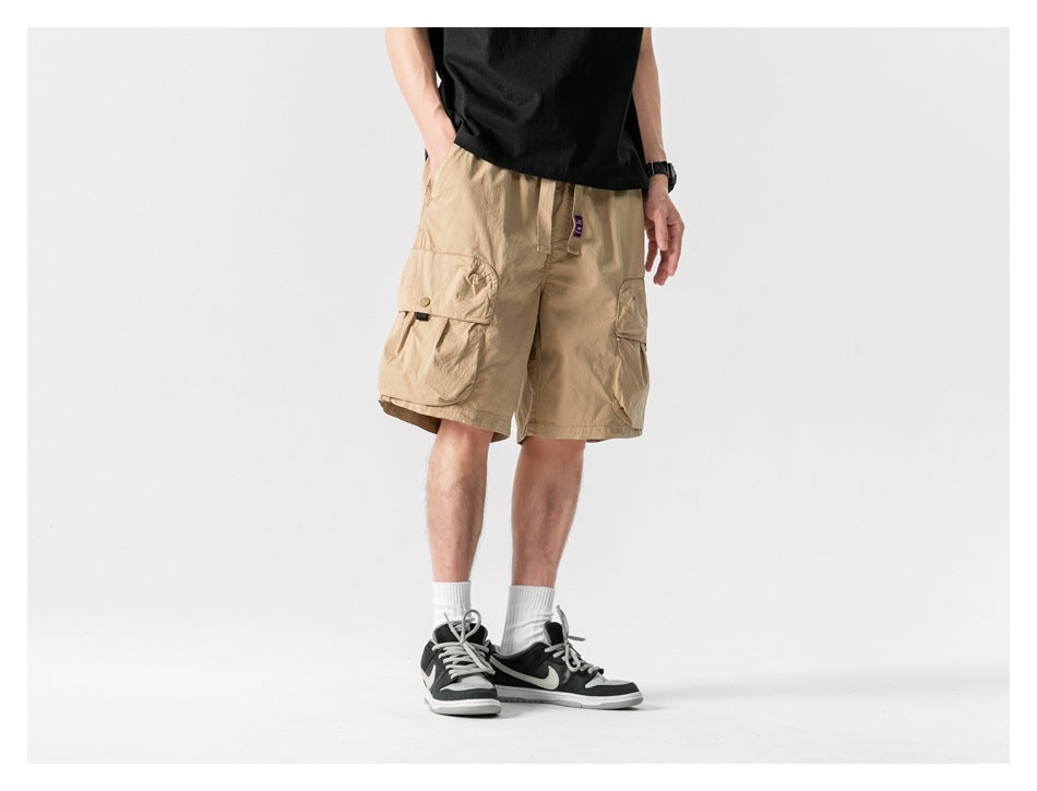 Model wearing tan cargo shorts with large flap pockets, shown from the front at a slight angle.