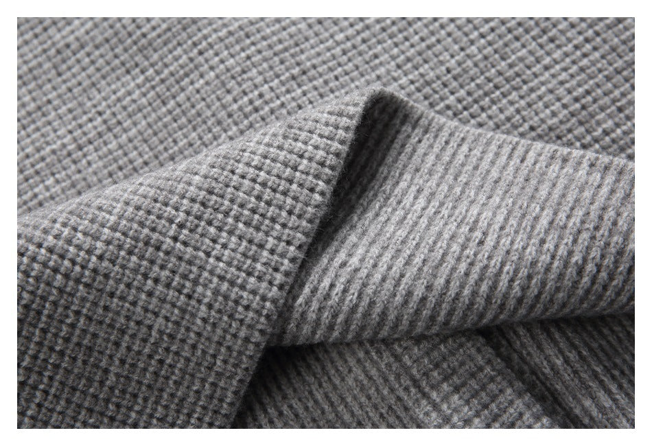 Close-up of gray fabric showing a small, raised grid texture and a folded ribbed edge.