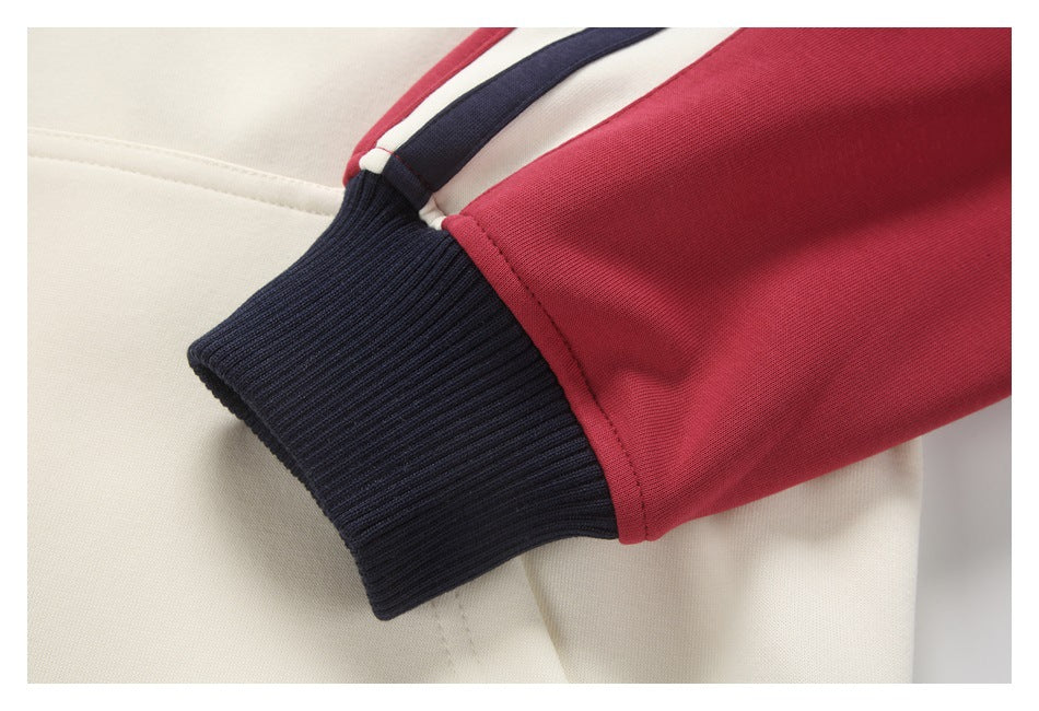 Close-up of a red sleeve with a ribbed navy cuff and ivory, navy, and red trim.