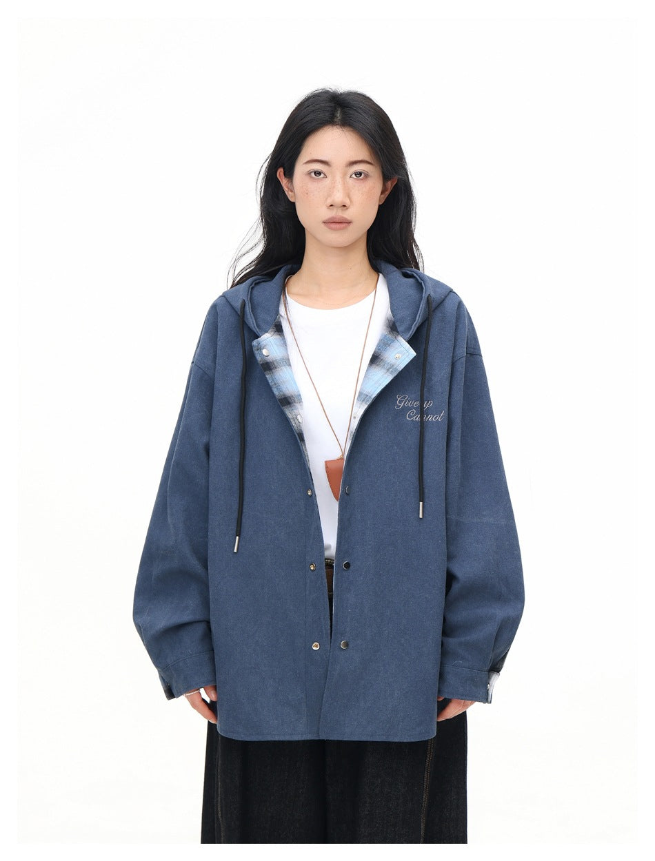 Model wearing a solid blue hooded button-front jacket with plaid lining visible at the opening.