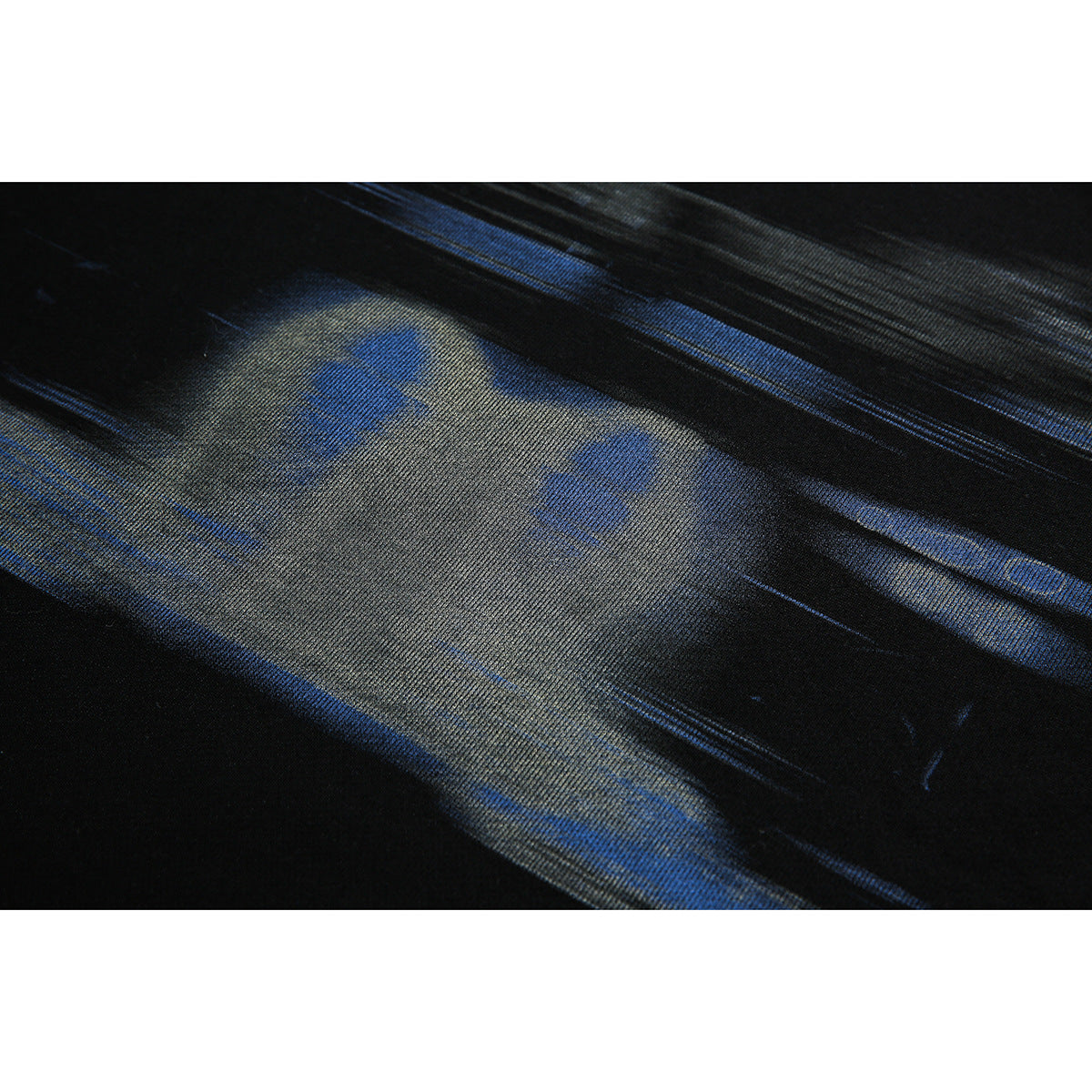 Close-up of a black garment showing an abstract blue and gray printed design.