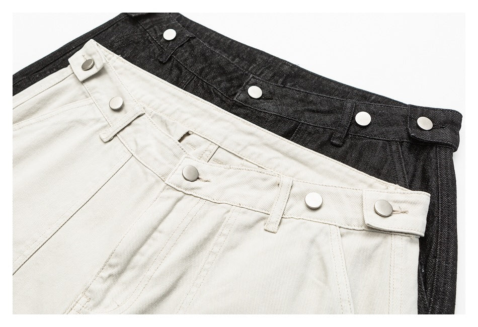 Close-up of off-white and charcoal shorts waistbands with silver snap buttons.