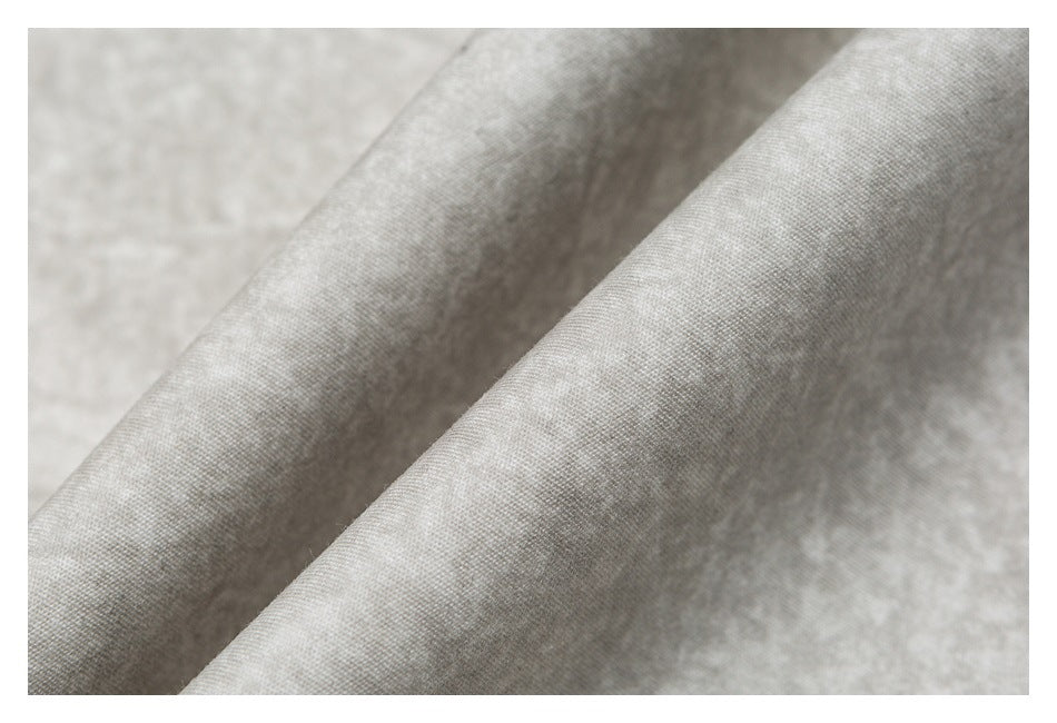 Close-up of the light beige mottled fabric, showing its surface texture and folds.