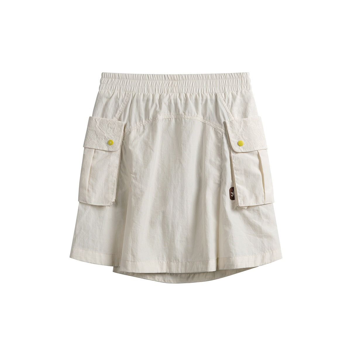 Front view of an ivory short skirt with an elastic waist, large cargo pockets with yellow snaps, and a layered hem.