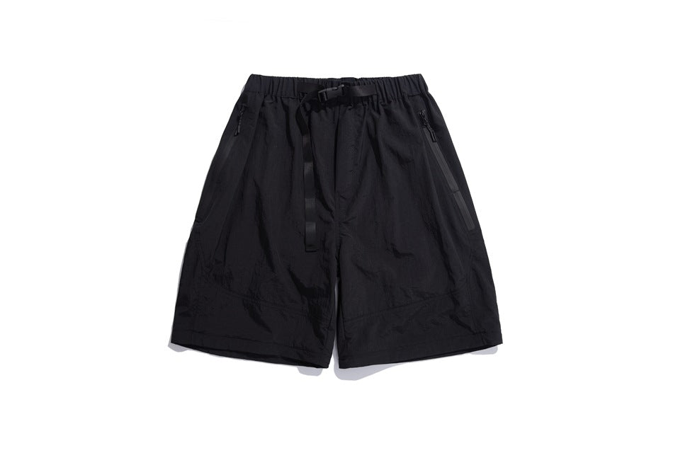 Black shorts with an elastic waistband, long adjustable belt strap, and angled zip pockets, shown from the front.