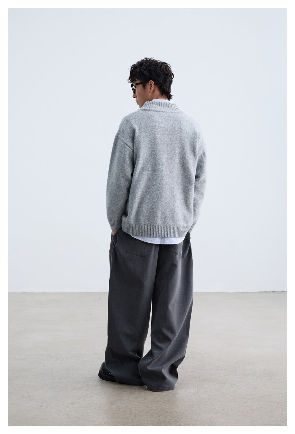 Back view of a model wearing a light gray cardigan with a ribbed collar, cuffs, and hem.