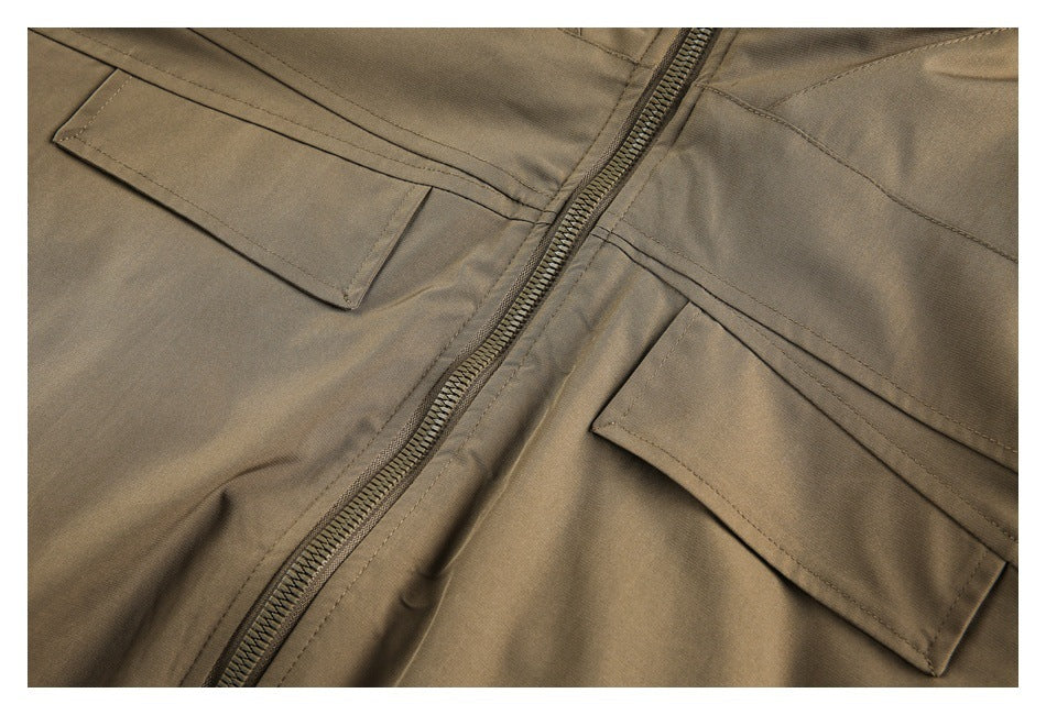 Close-up of tan trousers showing the front zipper and two flap cargo pockets.