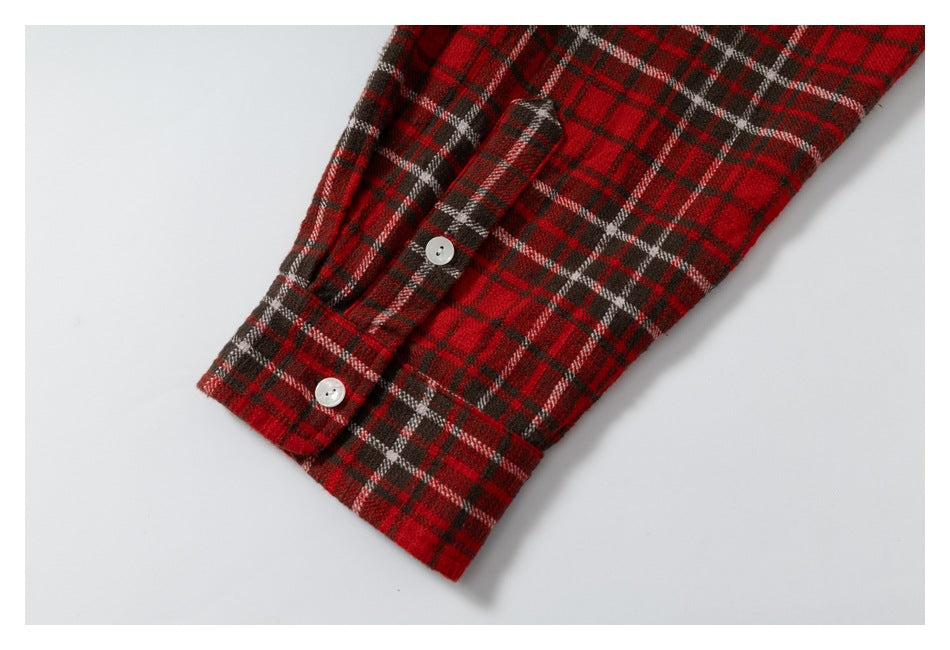 Close-up of a red plaid sleeve cuff with two white buttons.