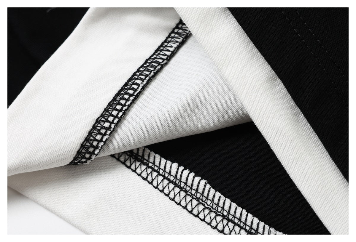 Close-up of black-and-white garment fabric and contrasting overlock stitching.