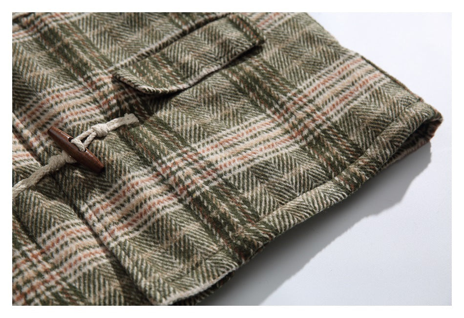 Close view of the plaid coat hem, flap pocket, and wooden toggle closure.