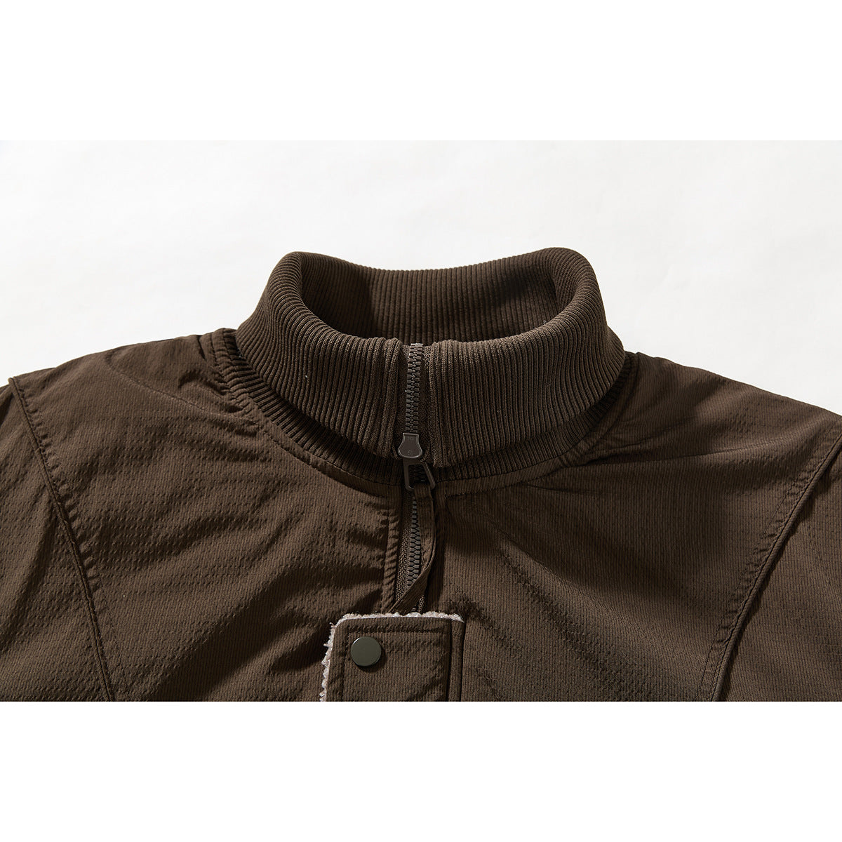 Close-up of a dark brown jacket's ribbed stand collar, front zipper, and snap-fastened placket.