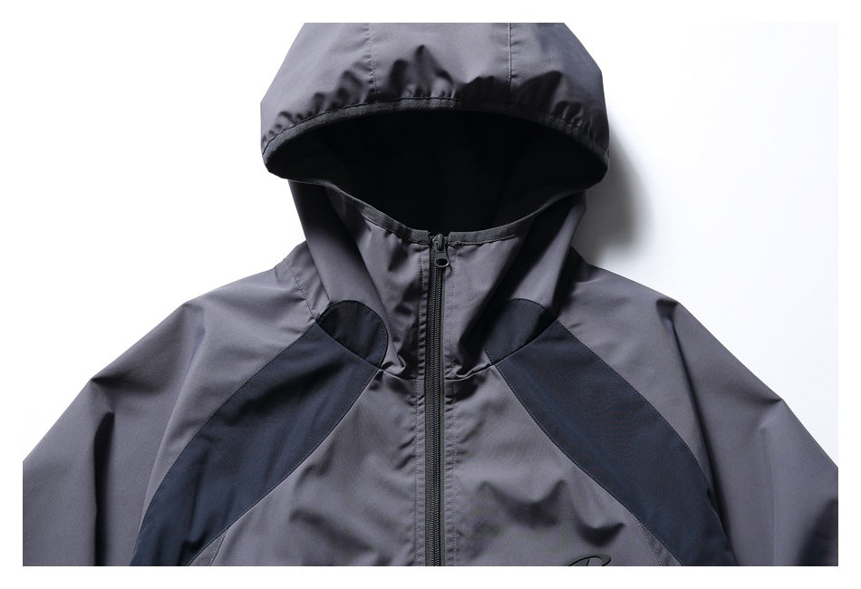 Close-up of the charcoal-gray jacket's hood, high collar, center zipper, and dark shoulder panels.