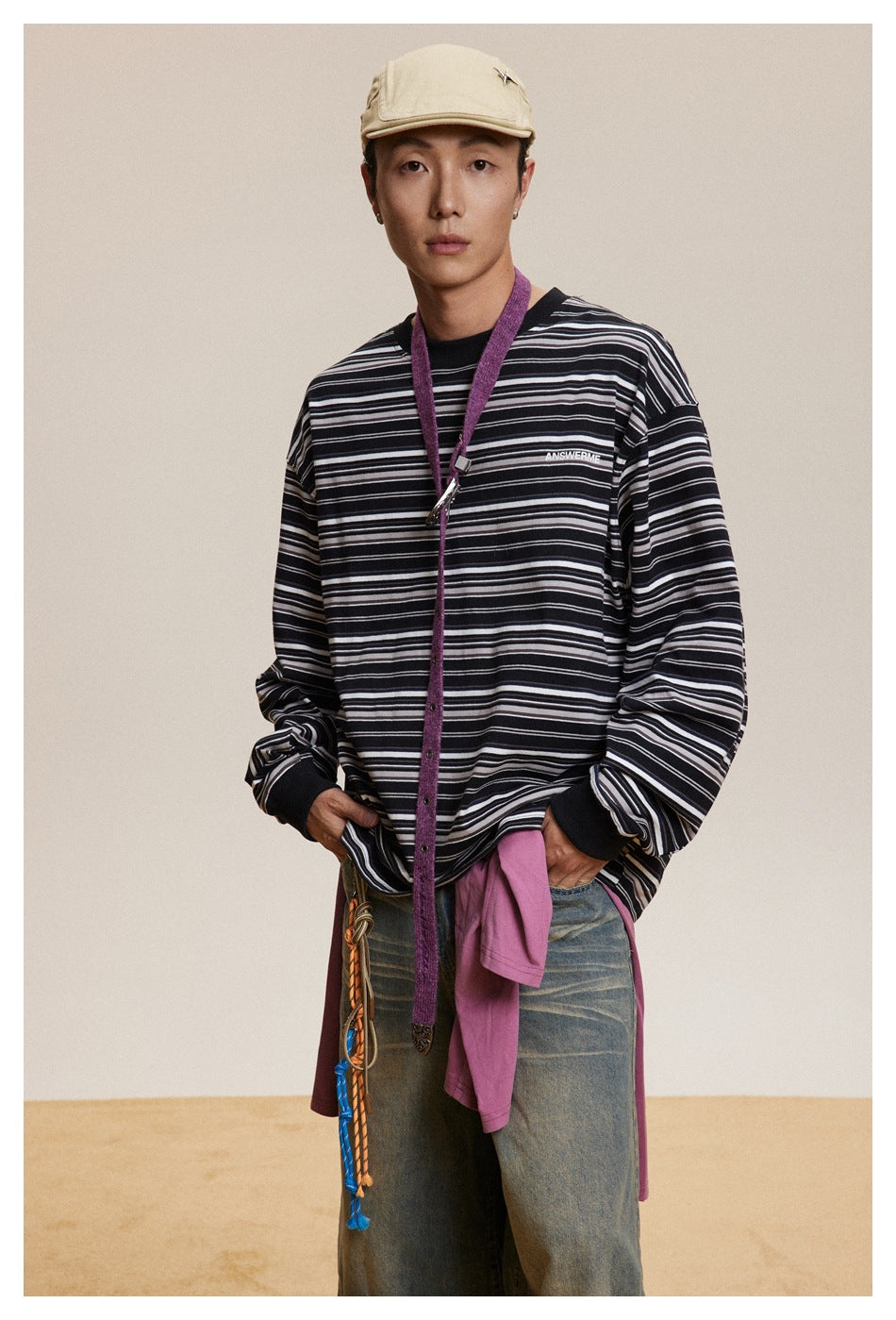 Model wearing a black long-sleeve crewneck shirt with white and gray horizontal stripes.