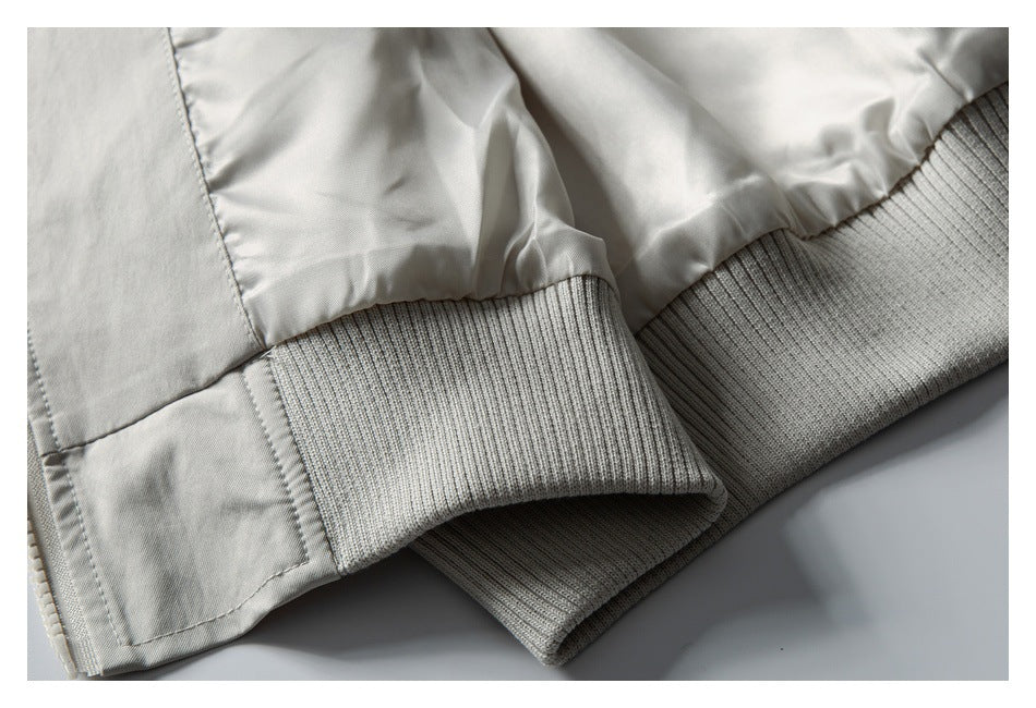 Close-up of the pale gray jacket's rib-knit cuff and waistband.