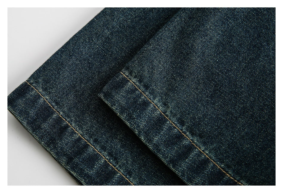 Close-up of the dark indigo denim shirt hem with tan contrast stitching.