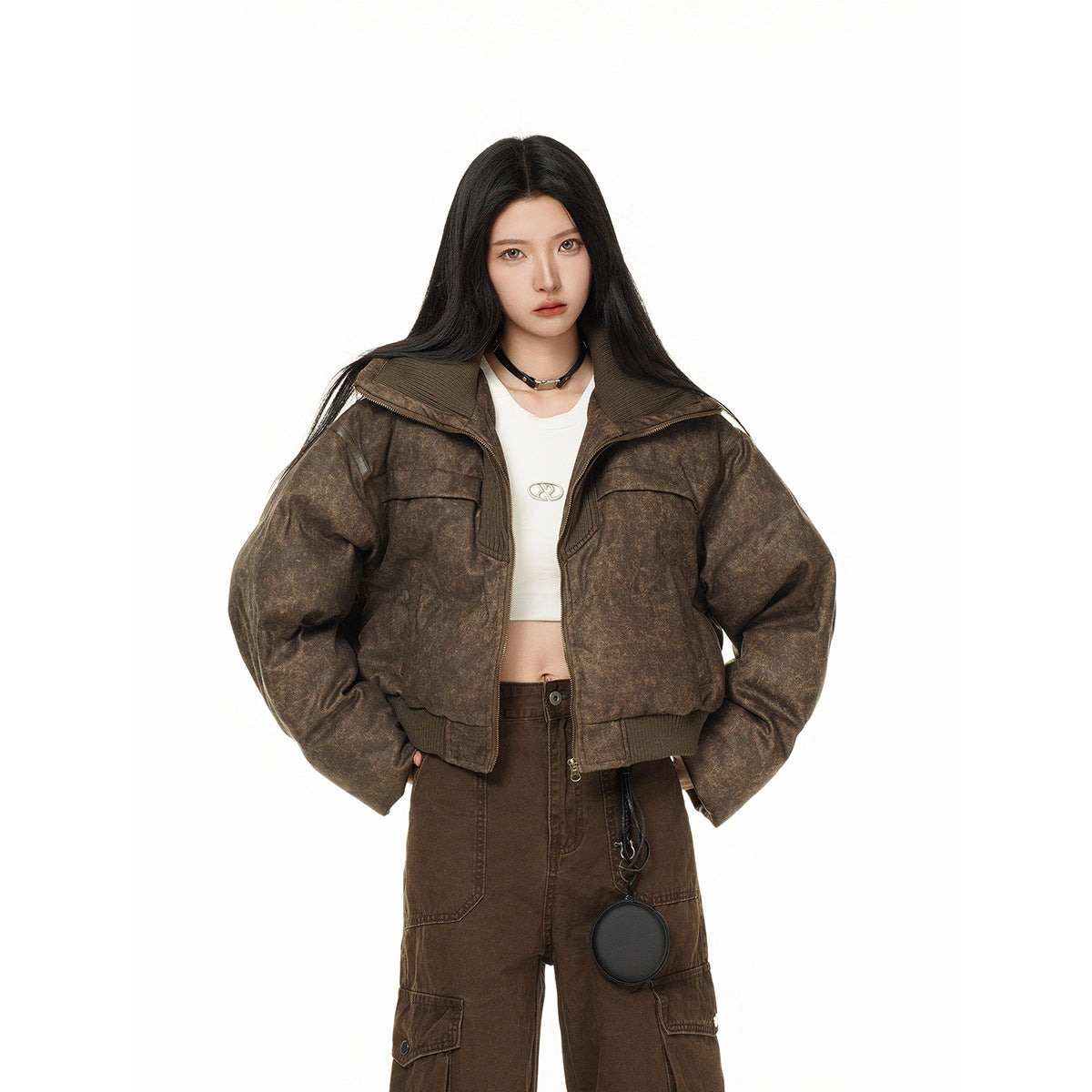 Front view of a model in a mottled brown cropped jacket with a wide collar, paired with a white top and brown cargo pants.