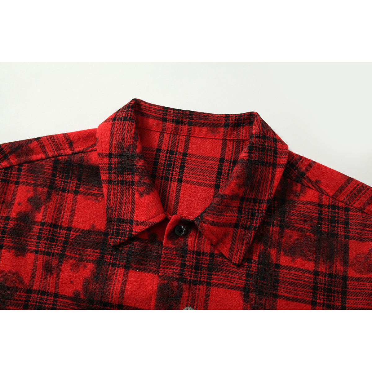 Close-up of a red-and-black plaid shirt collar, neckline, and top button.