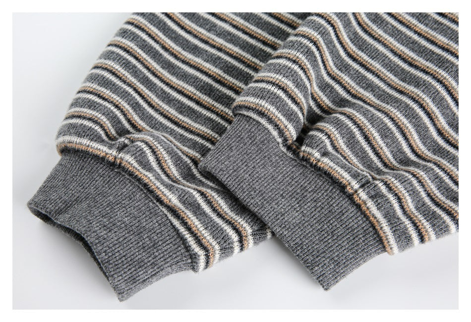 Close-up of gray striped knit sleeves with ribbed cuffs and thin cream and tan stripes.