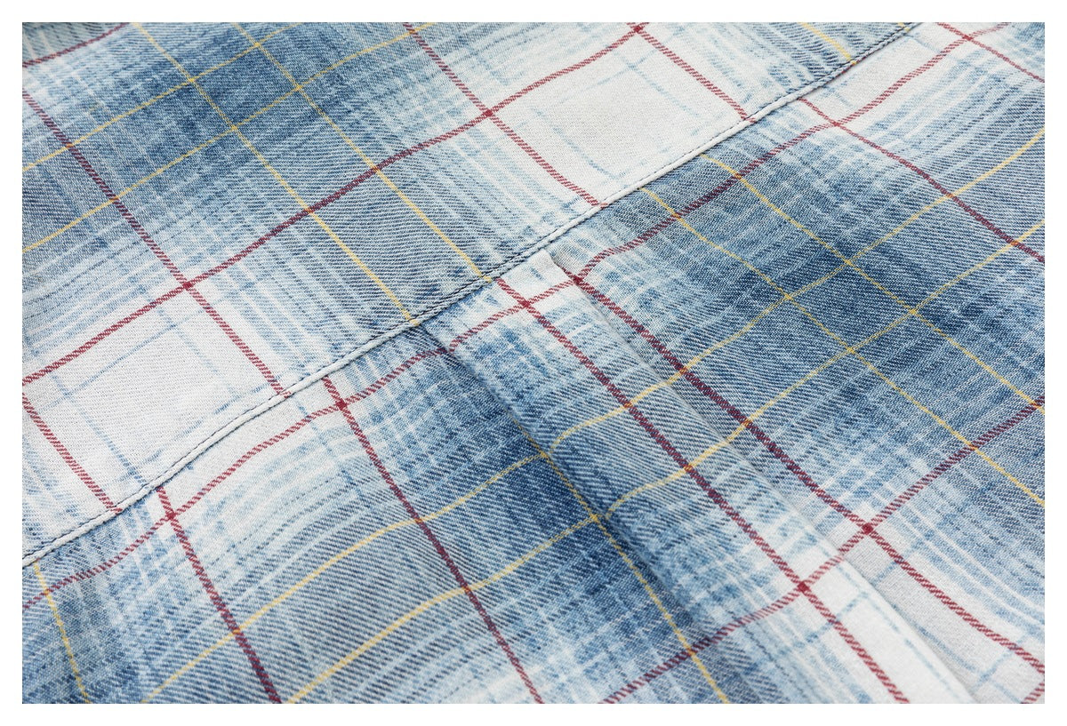 Close-up of blue, white, red, and yellow plaid fabric showing a stitched seam.