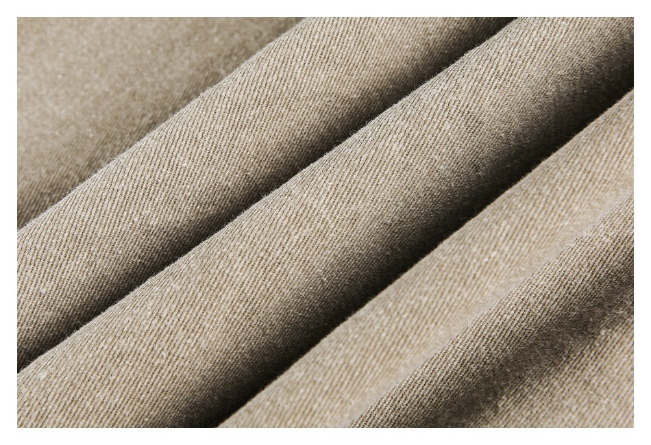 Macro view of the fine diagonal weave and folds in beige-tan fabric.