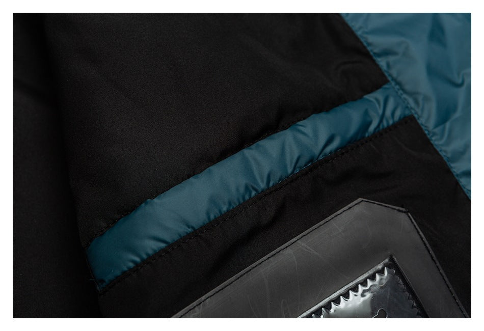 Close-up of black and teal padded garment panels with stitching and part of a dark rectangular patch.