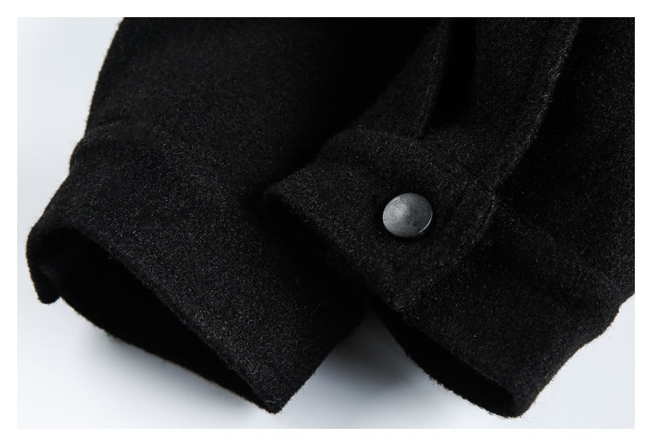 Close-up of a black garment cuff with a round dark snap button.