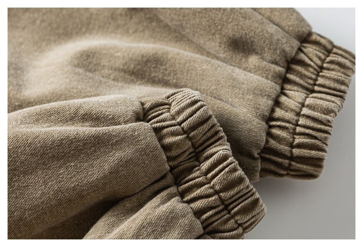 Close-up of gathered elastic cuffs on tan garment fabric.