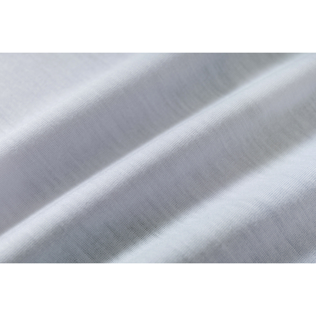 Macro view of pale fabric draped in soft folds, showing its fine knit texture.