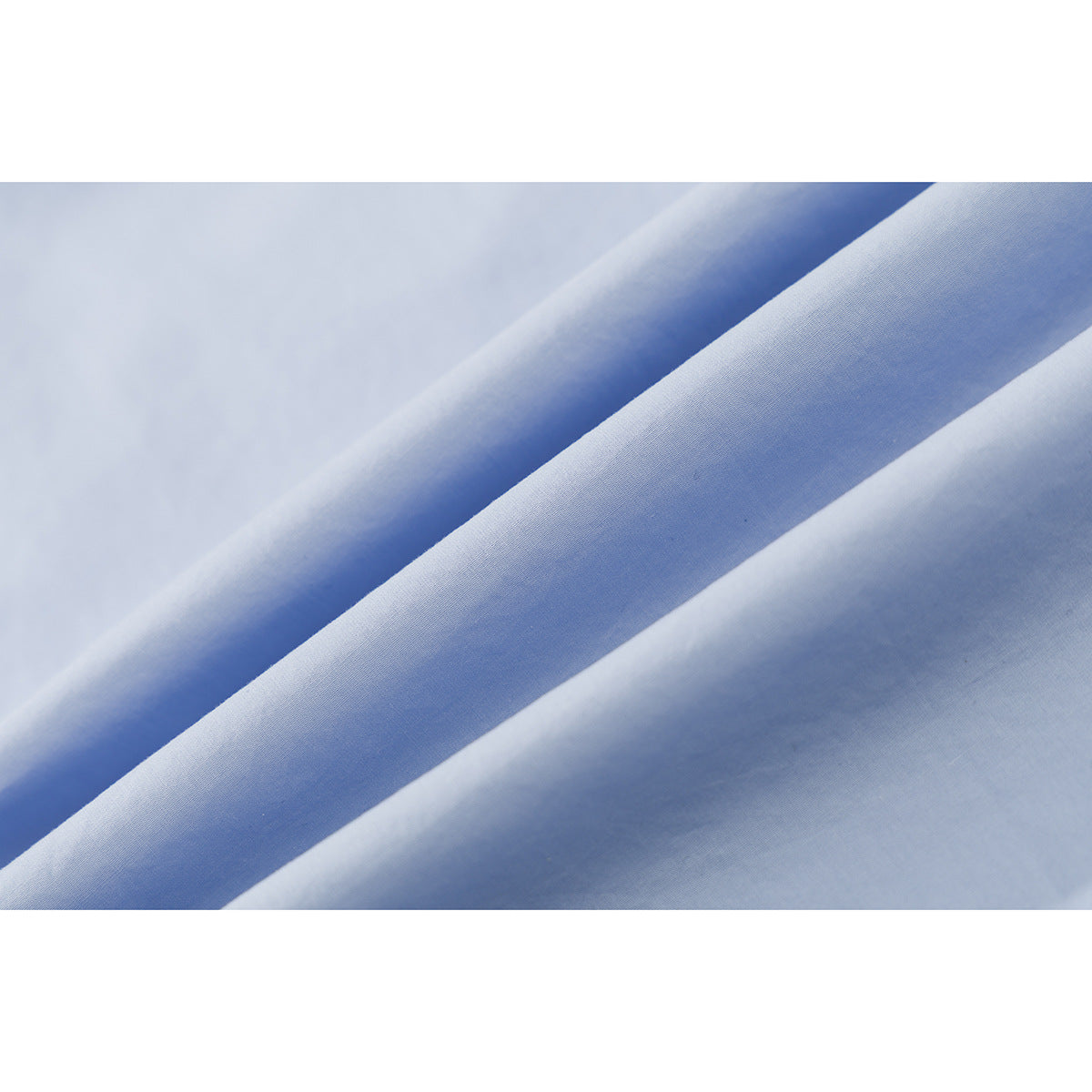 Close-up showing the smooth, pale blue surface and folds of shirt fabric.