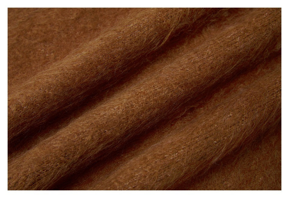 Close-up of the sweater's soft-looking brown knit fabric folded into diagonal ridges.