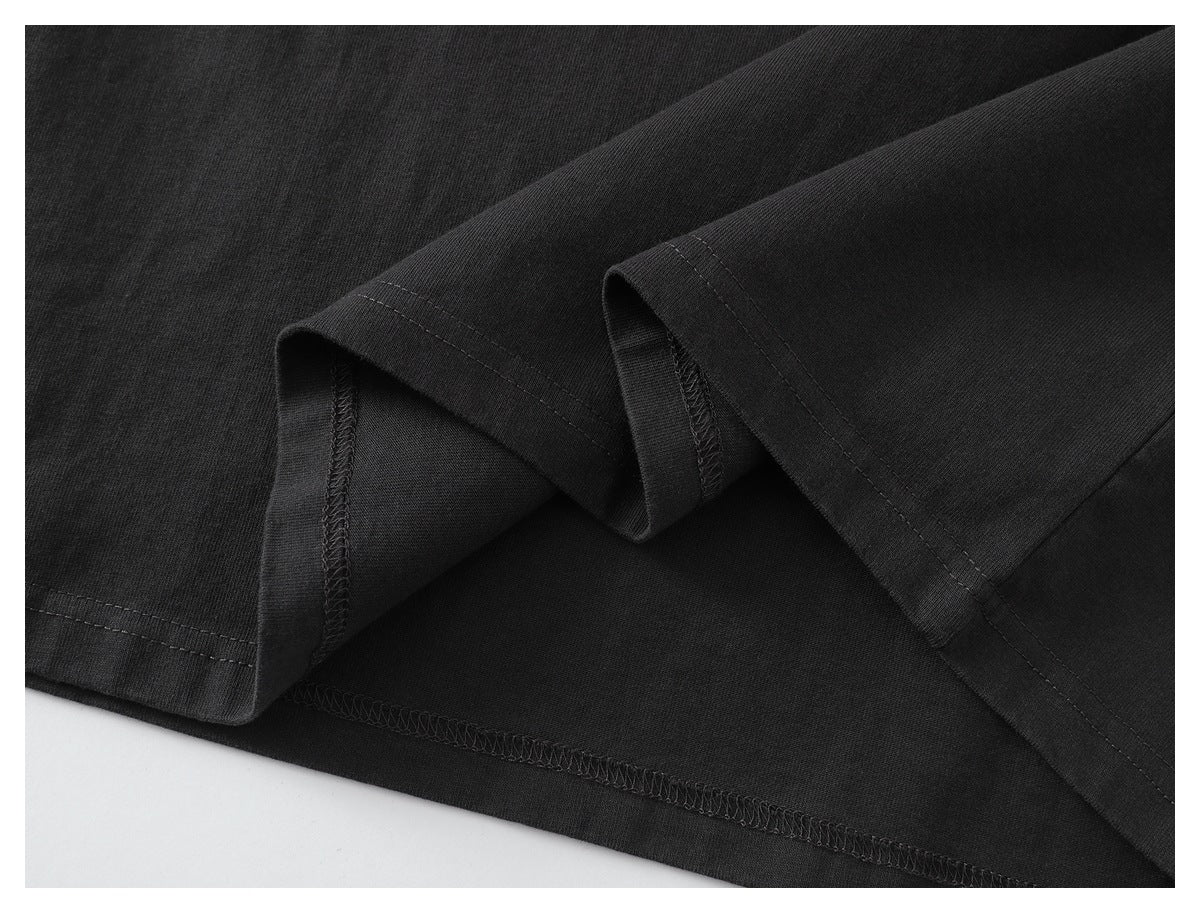 Close-up of the black garment hem showing stitching and overlocked seams.