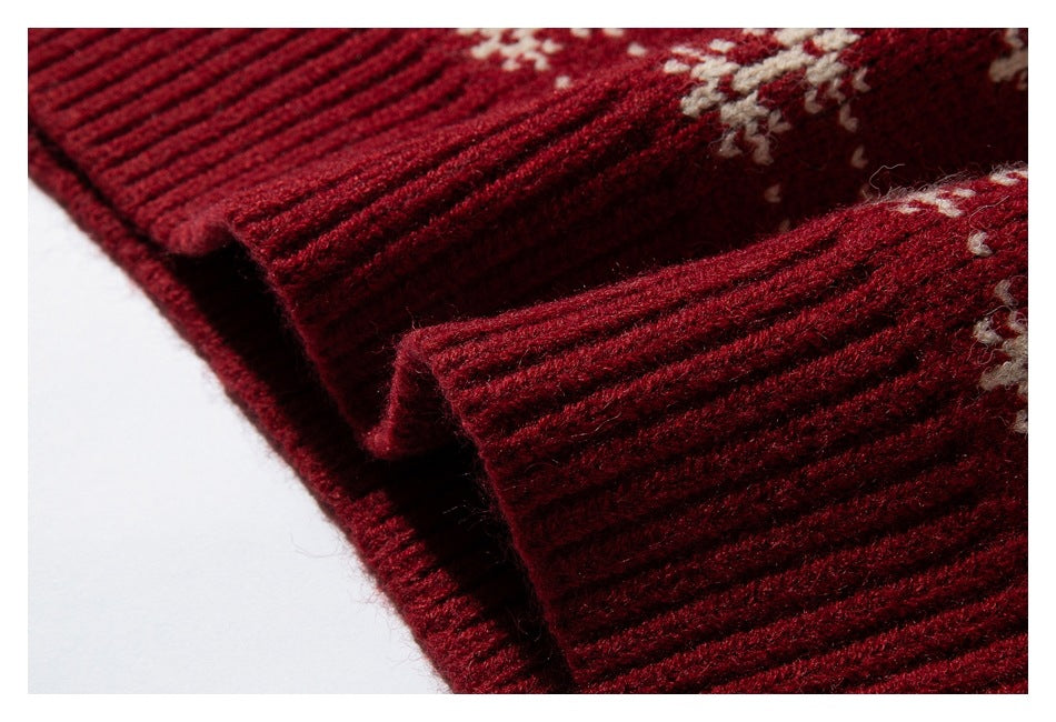 Close-up of the deep red garment's thick ribbed edge beside cream knit patterning.