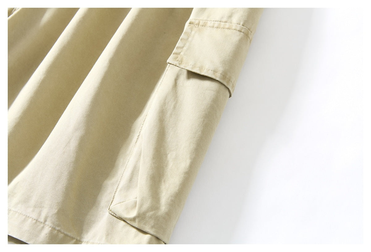 Close-up of a beige trouser leg showing a flap cargo pocket and the hem.