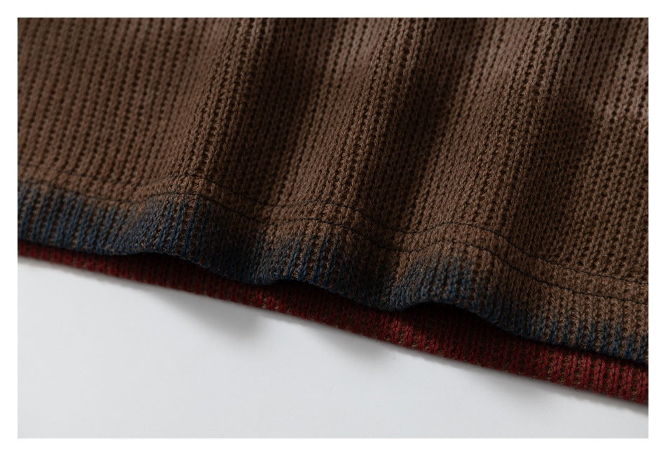 Close-up of a brown rib-knit garment hem with dark blue edging and a red layer visible beneath.