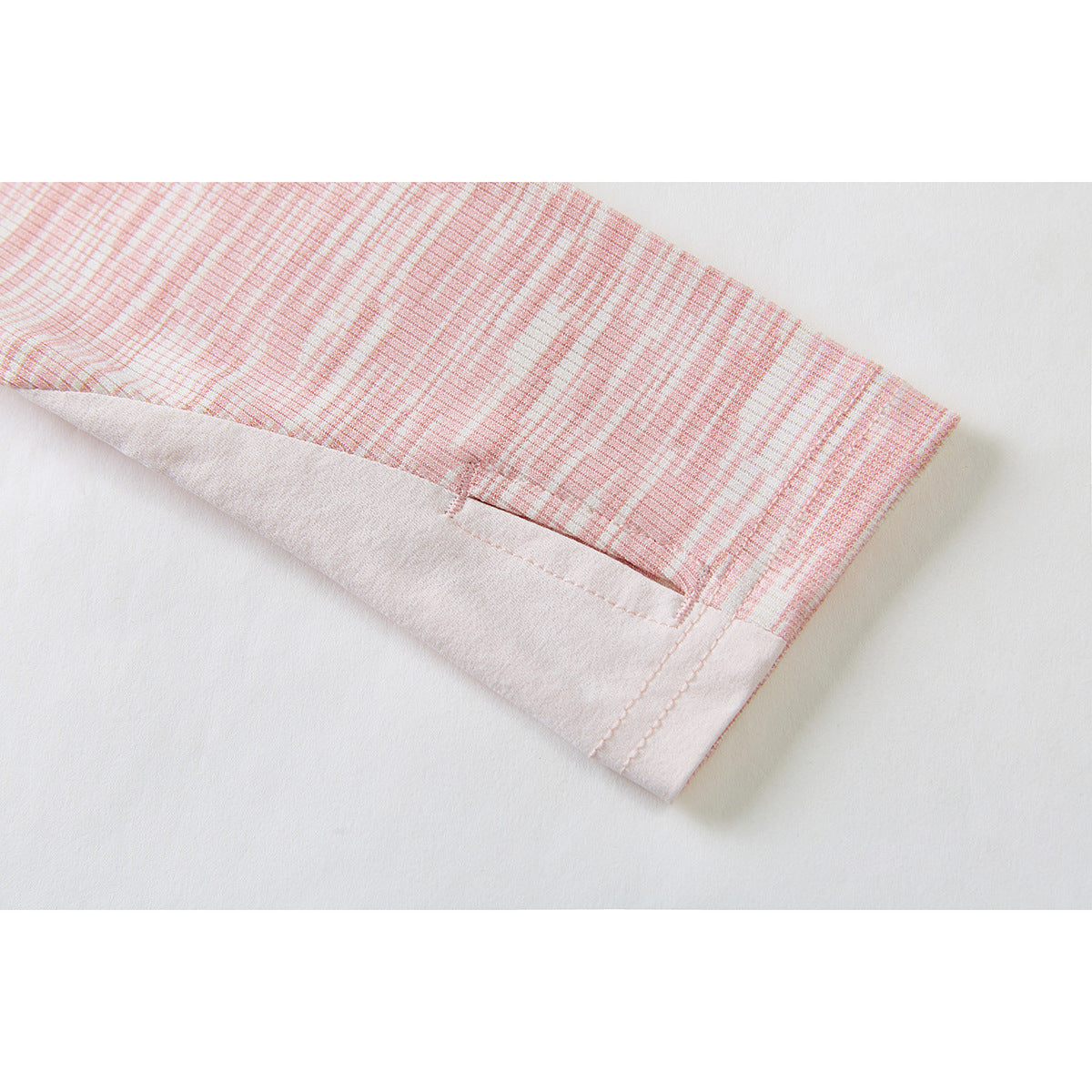 Close-up of a pink-and-white patterned sleeve with a pale pink cuff and a small slit near the hem.