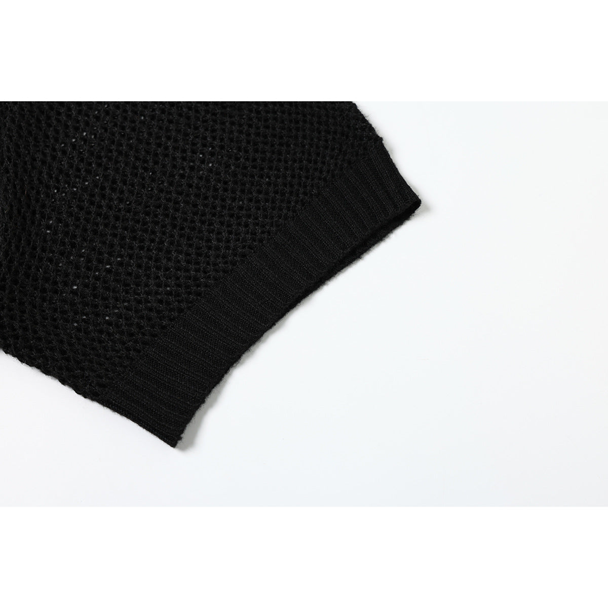 Close-up of the black open-knit short sleeve and its ribbed cuff.