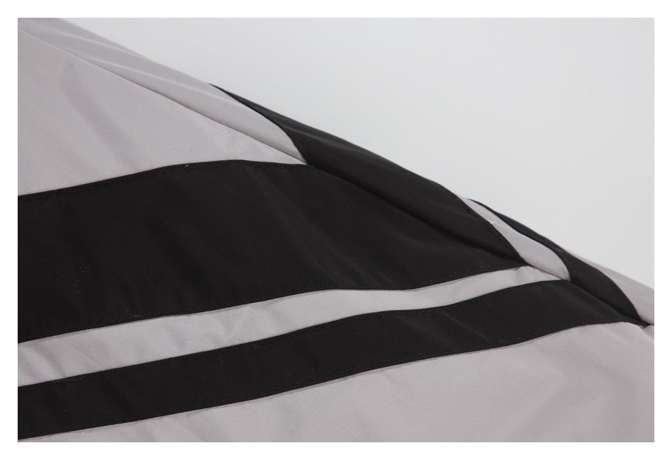 Close-up of black and light gray stripe panels and seams on a light gray garment.