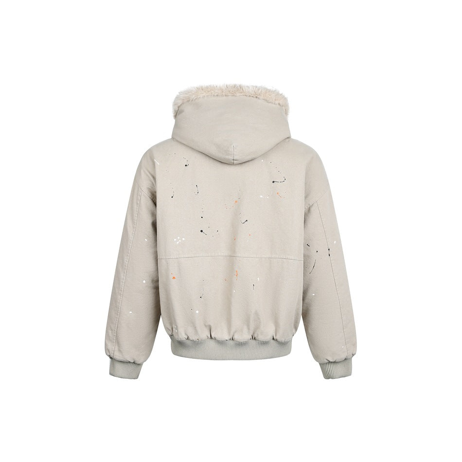 Rear view of a light beige hooded jacket with cream fur trim, scattered paint splatters, and ribbed cuffs and hem.